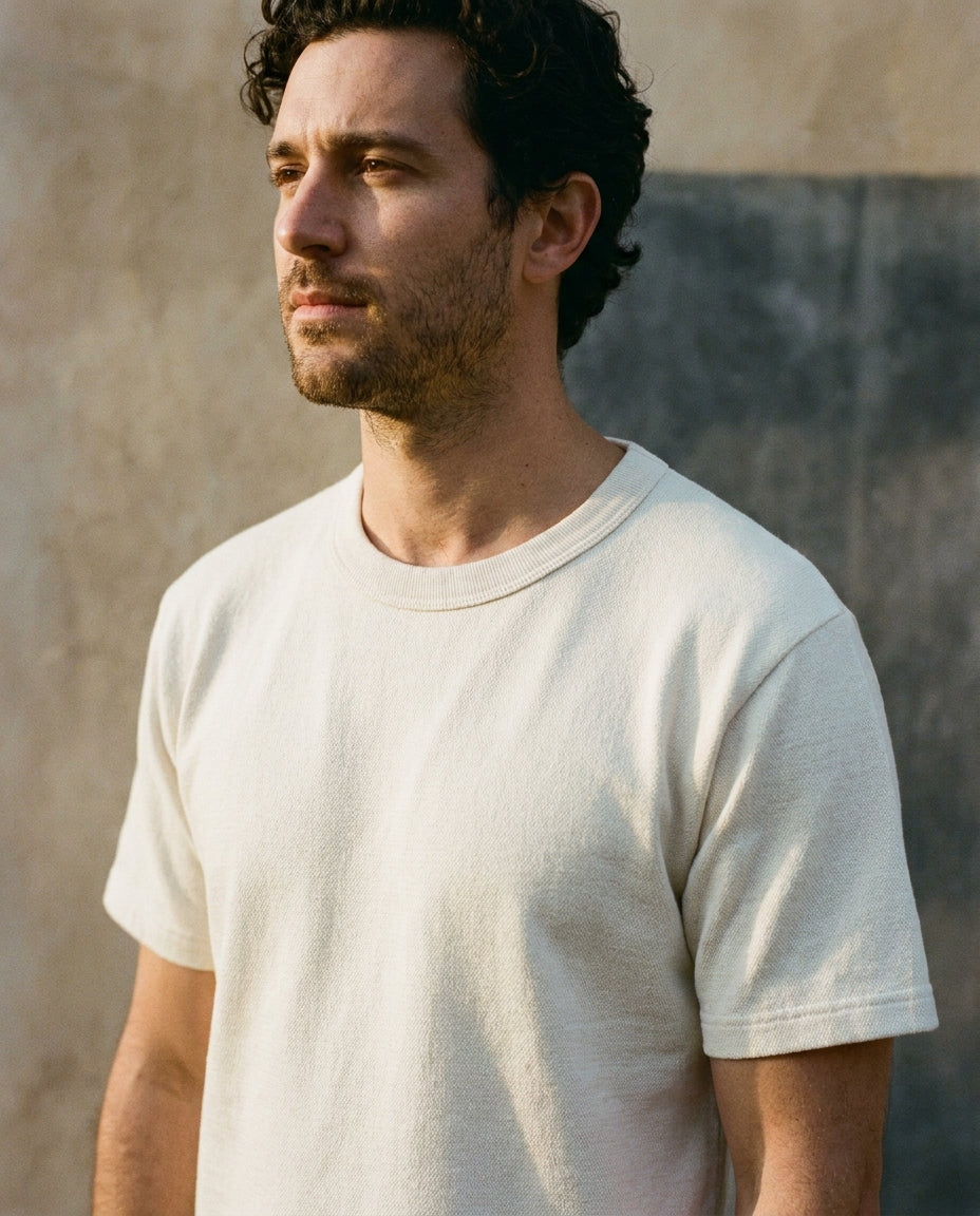 CRAFT Heavyweight Tee in ivory, worn against a limewash wall