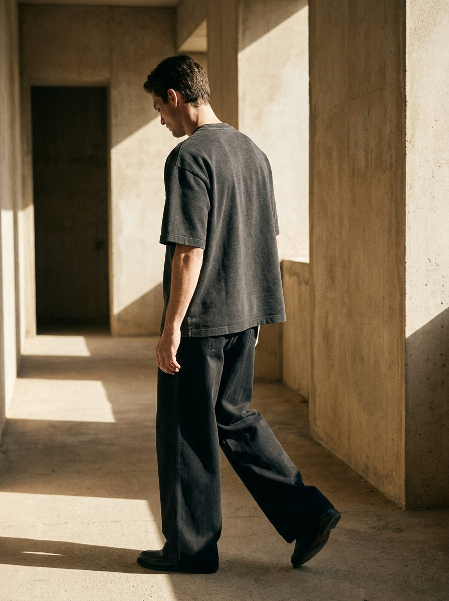 CRAFT tee in charcoal, worn walking through a sunlit corridor